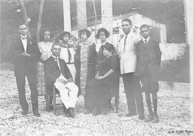 La famille Georges Sylvain, 1921 Assis, de gauche à droite: Monsieur Georges Sylvain (décédé en 1925) et Madame Sylvain (morte en décembre 1931). Derrière, les enfants (de gauche à droite): Henry, Yvonne, Jeanne, Suzanne, Madeleine (-Bouchereau), Normil et le cadet, Pierre. D.R. photo léguée par M. Jean Comhaire à K. Gyssels